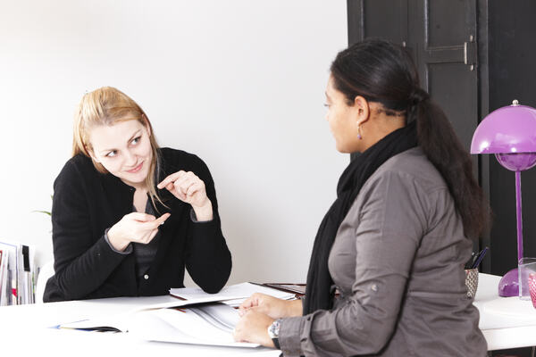 To damer i samtale, der den illustrerer begrepet lite med hendene