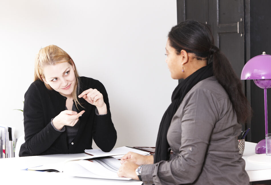 To damer i samtale, der den illustrerer begrepet lite med hendene