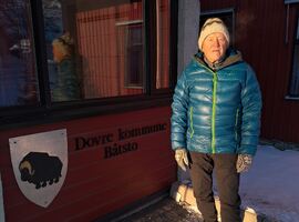 Mann i blå boblejakke står foran Dovre kommunes rådhus
