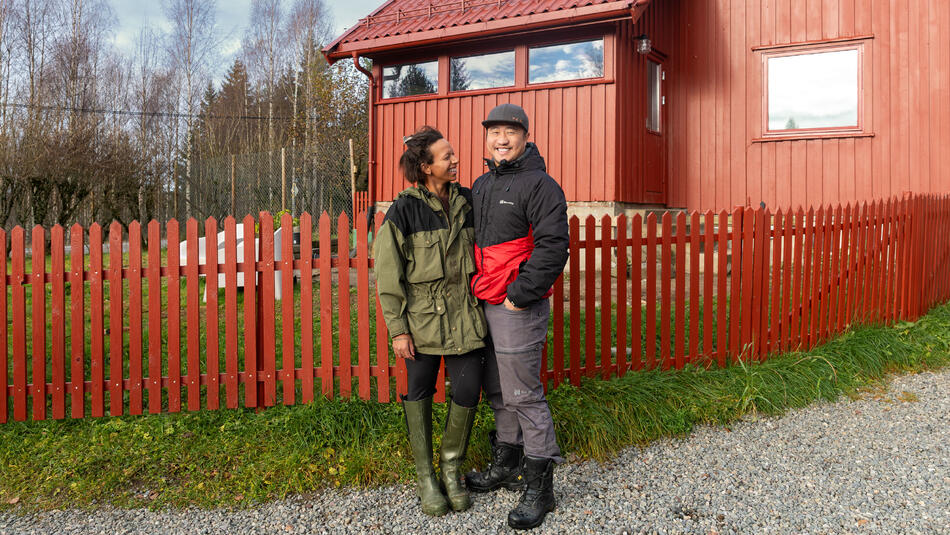 Mann og dame foran et rødt hus