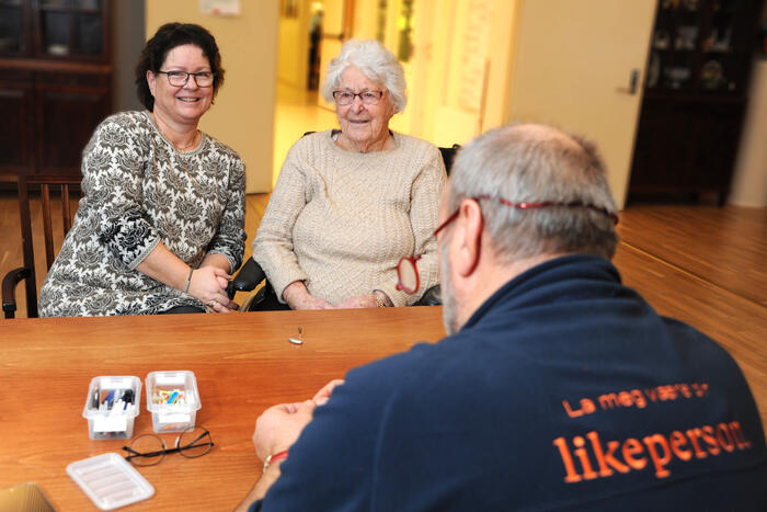 Mann sitter med mor og datter