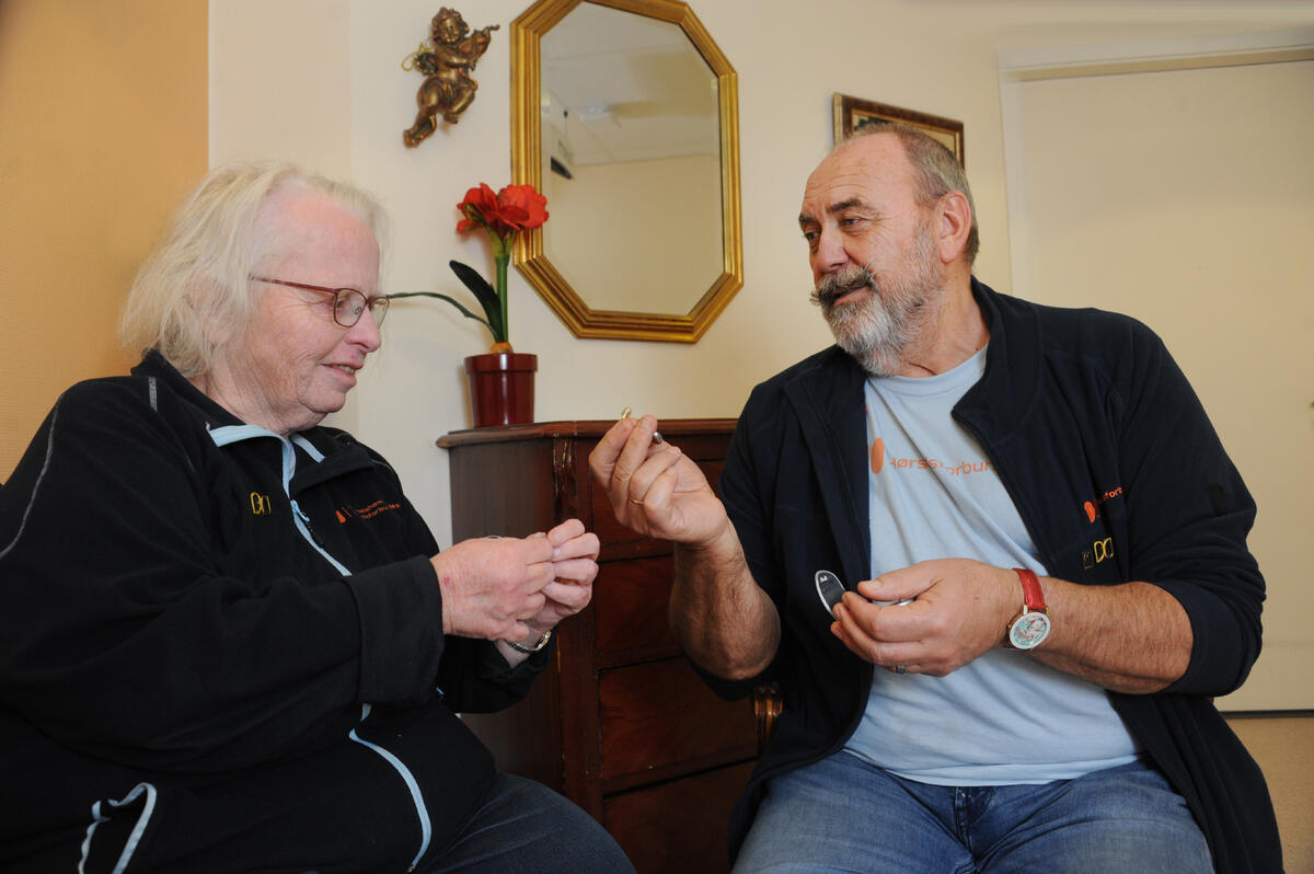 GODT TEAM. John Sandvik og Gro Wenche Rognlien har jobbet sammen som ambulerende hørselshjelpere i fylket siden koronapandemien. Hver måned besøker de sju sykehjem i Østfold. Mann og dame snakker sammen