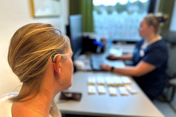 pasient med høreapparat sitter hos audiograf