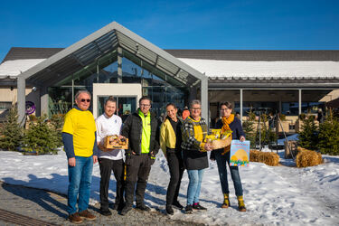 Påskepyntede personer foran bakeribygning