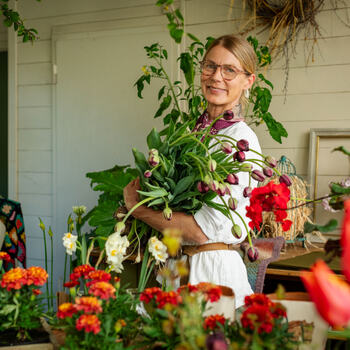 Benedicte som holder en stor bukett tulipaner