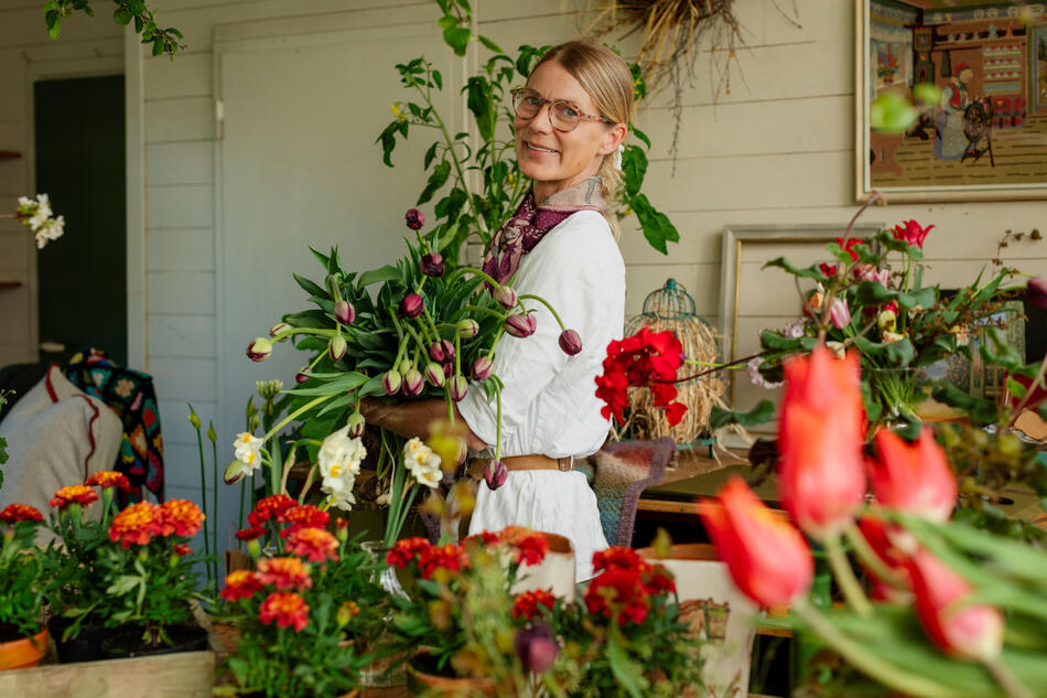 Benedicte som holder en stor bukett tulipaner