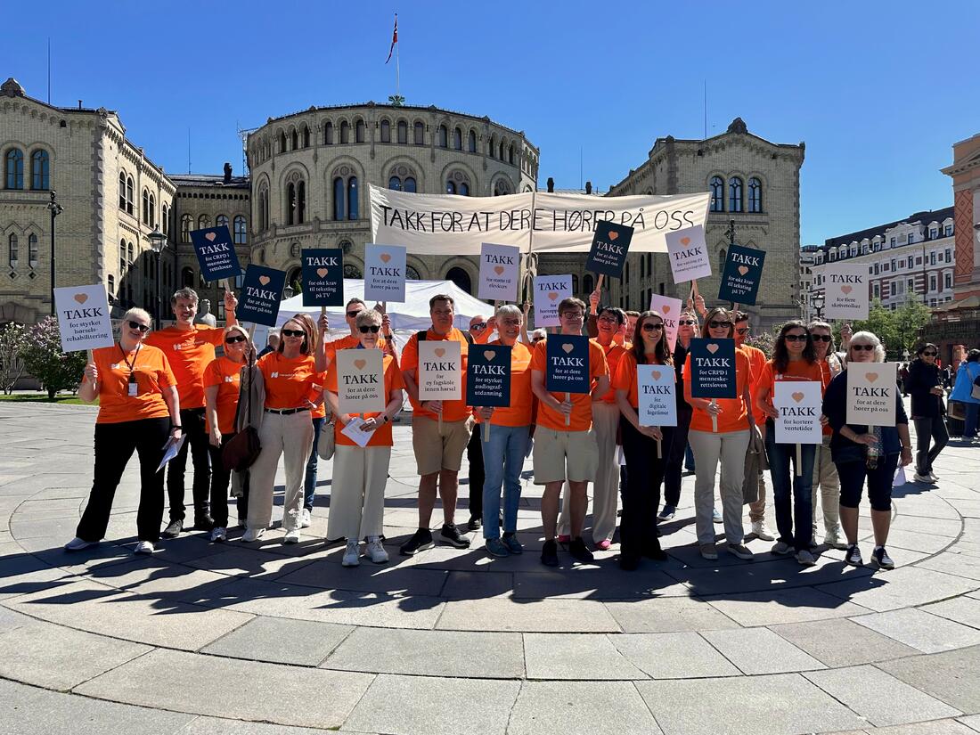 Folkemengden i oransje t-skjorter og plakater foran Stortinget