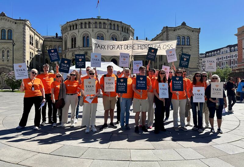 Folkemengden i oransje t-skjorter og plakater foran Stortinget