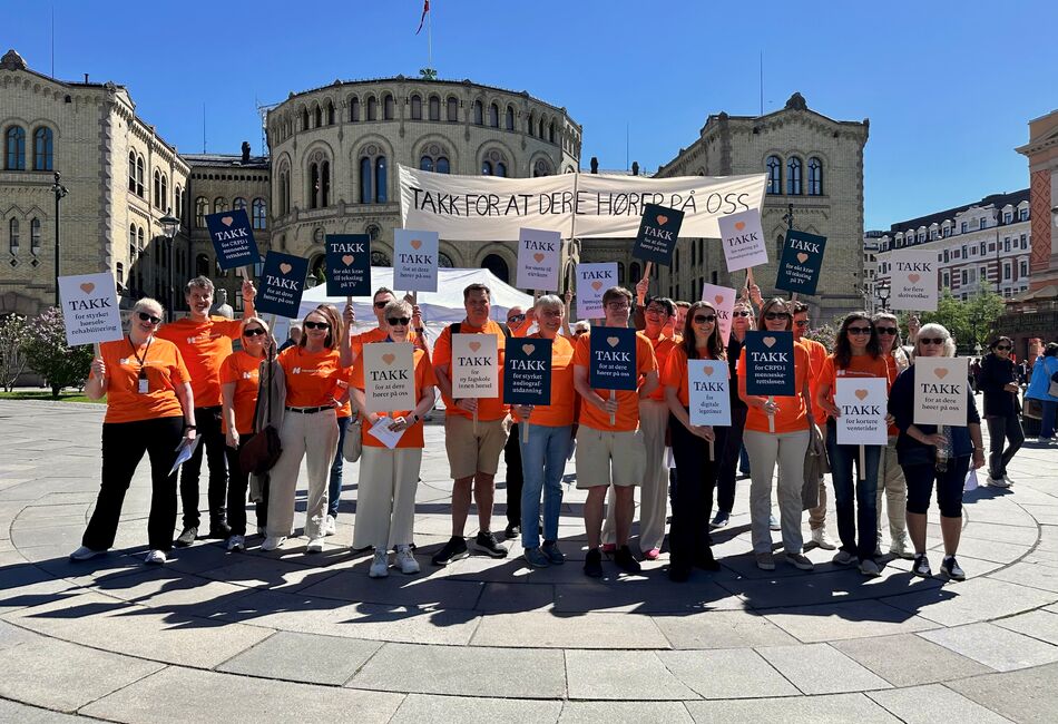 Folkemengden i oransje t-skjorter og plakater foran Stortinget