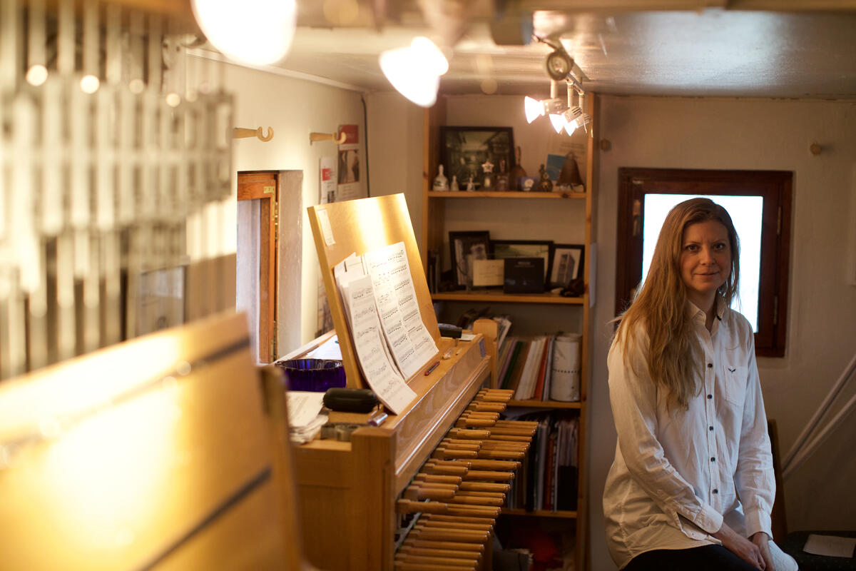 Dame med orgellingende instrument i bakgrunnen