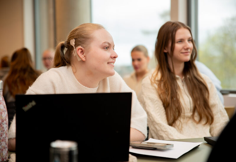 To studenter sitter konsentrert og lytter