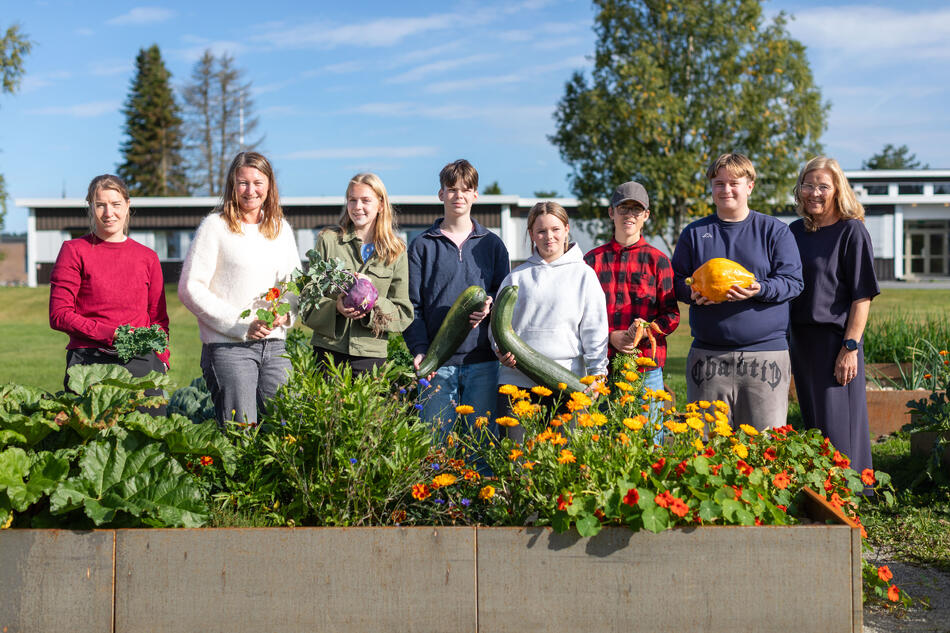 Foto (f.v.): Lærerne Magnhild Skattebu og Ingrid Trøstheim, elevene Vilde Haug Berg, Chris Droesler, Cassandra Droesler, Adrian Aasen og Heine Mathias Nordby, og rektor Inger S. Mo Stabo-Eeg. Gruppebilde med lærere, elever og rektor i skolehagen